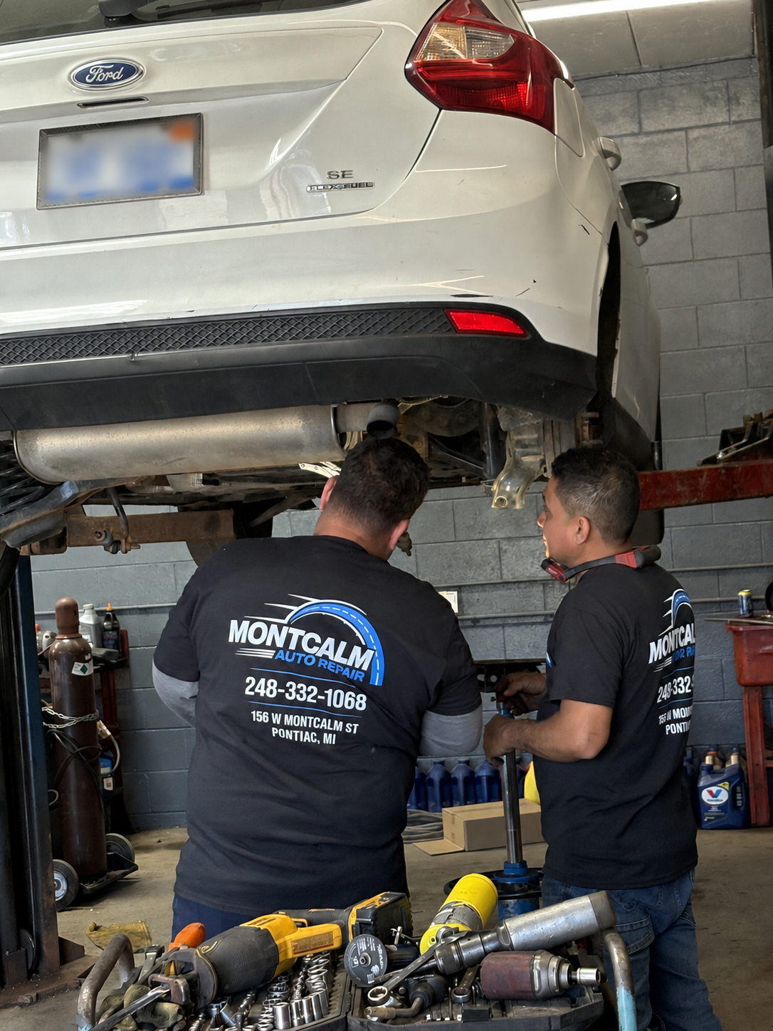 Montcalm Auto Repair technicians working beneath a vehicle on a lift